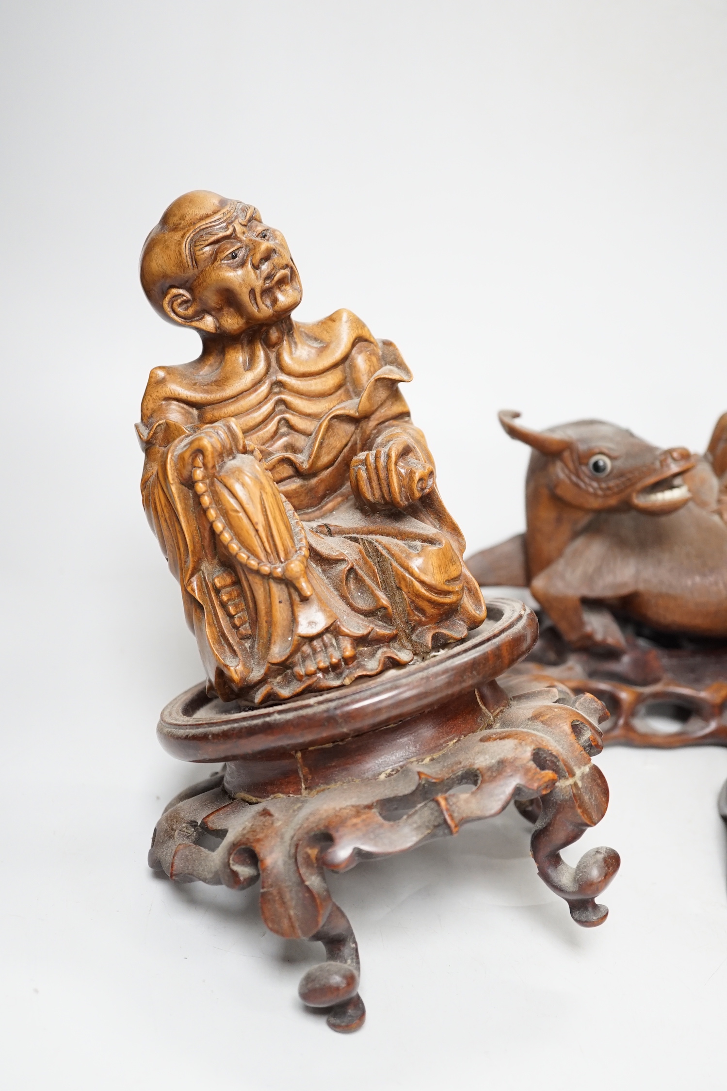 A pair of Chinese carved hardwood buffalo carvings, and a similar figure of a luohan, latter 24cm - damaged